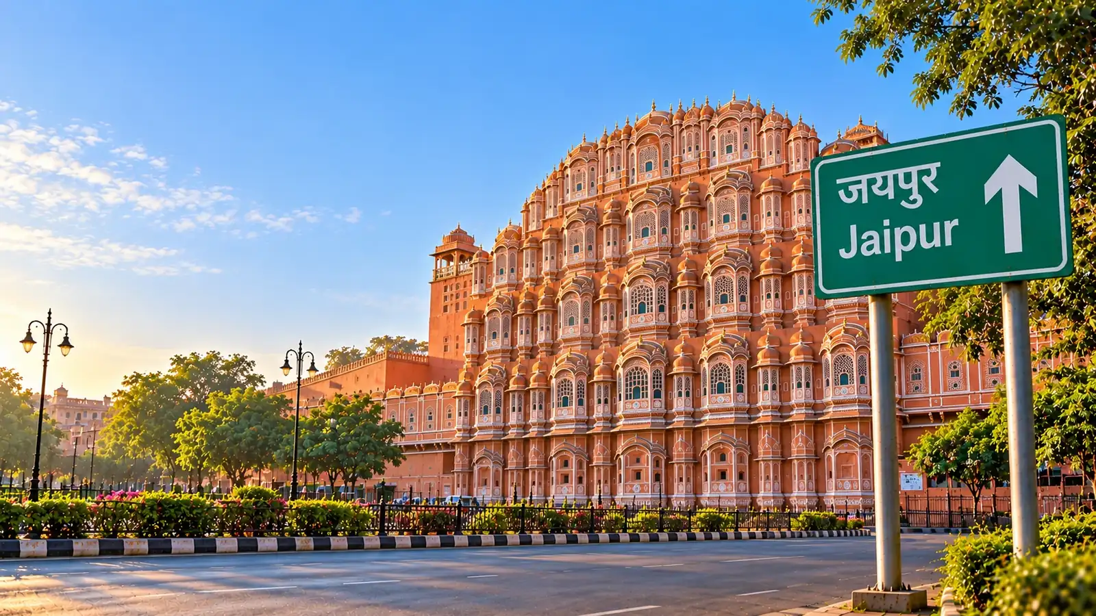 Hawa Mahal in Jaipur in morning light behind a quiet road, with a green highway sign reading Jaipur